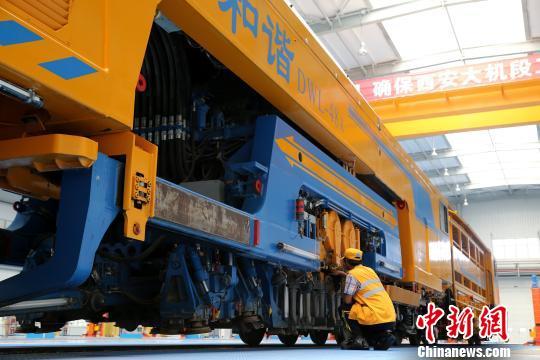圖為工人正在清理大型養(yǎng)路機(jī)械?！堖h(yuǎn) 攝